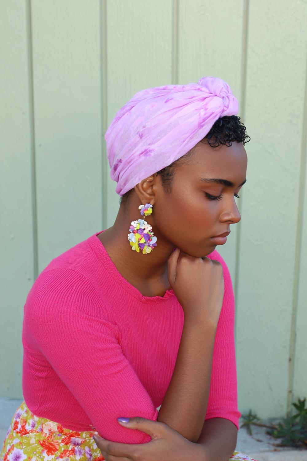 19. Urlaubs Frisuren 2026: Tuch-Turban über Locken mit Ohrring-Fokus